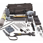 Comprehensive tool kit spread on a white background, featuring a black carrying bag and a variety of hand tools including pliers, wrenches, screwdrivers, drill bits, a tape measure, blades, and a hacksaw.