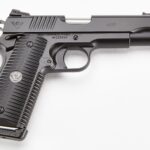 Side view of a black semi-automatic pistol with textured grip and engravings 'ACP' and 'Wilson Combat' on the slide, on a white background.