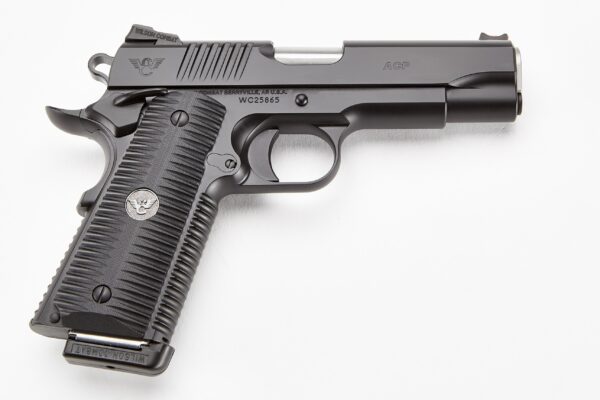 Side view of a black semi-automatic pistol with textured grip and engravings 'ACP' and 'Wilson Combat' on the slide, on a white background.