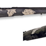 Bolt-action rifle with tan and black camouflage, a long barrel with a muzzle brake, shown on a white background.