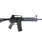 AR-15 style rifle with collapsible stock, gray handguard, and magazine inserted, photographed in profile against white background