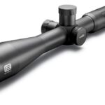 Black rifle scope with large objective lens and multiple adjustment dials, logo visible on the side